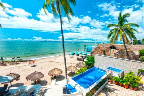 uma vista para uma praia com guarda-sóis e uma piscina em Vallarta Shores Beach Hotel em Puerto Vallarta