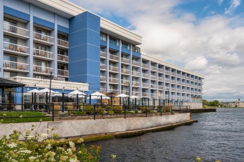a large building with a river in front of it at Holiday Inn Kingston - Waterfront by IHG in Kingston