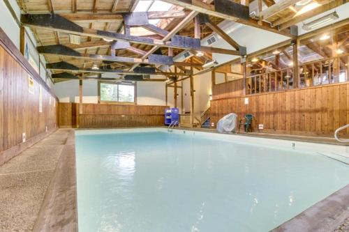a large swimming pool with wooden walls and a large indoor swimming pool at Mountainside Resort V in Stowe