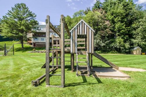 a wooden playground equipment in a grass field at Mountainside Resort V in Stowe