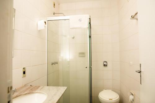 a bathroom with a shower and a toilet and a sink at Central Plaza Hotel Tupa in Tupã