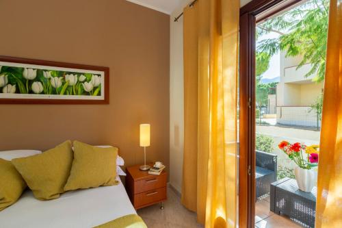 una camera da letto con un letto e una finestra con balcone di Residence Smeraldo a San Vito lo Capo