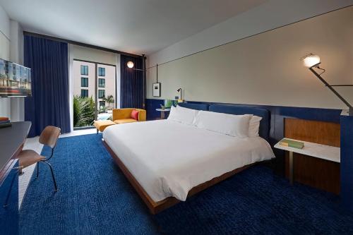 a bedroom with a large white bed and a couch at Hotel Haya in Tampa