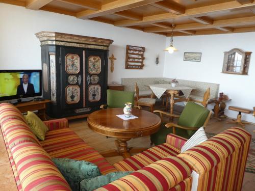a living room with couches and a table and a tv at Apartment Gerlitzen Ossiachersee - Haus Enzian in Treffen