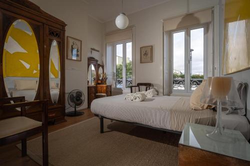 1 dormitorio con cama, mesa y ventanas en In53 Guest House en Ponta Delgada