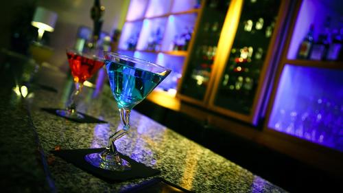 two wine glasses sitting on a counter in a bar at Crowne Plaza Shenandoah - The Woodlands Area by IHG in The Woodlands