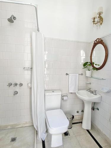 a white bathroom with a toilet and a sink at Hotel Chemin in Buenos Aires
