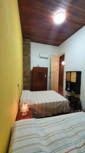 a bedroom with two beds and a wooden ceiling at Hostel Casa de Avany in Cachoeira