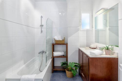 La salle de bains blanche est pourvue d'une baignoire et d'un lavabo. dans l'établissement WintowinRentals 1st Linea de playa vista al mar y piscina, à Cala del Moral