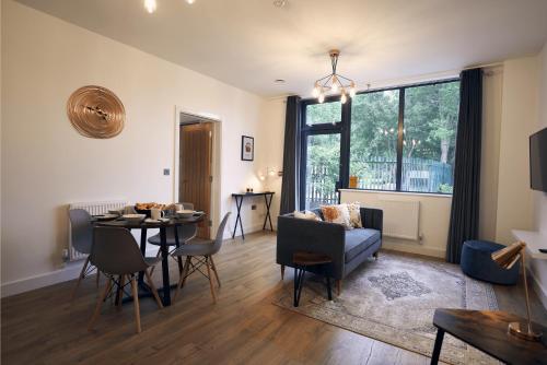 a living room with a table and a couch at Herongate Apartments in Hungerford