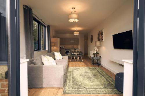 a living room with a couch and a television at Herongate Apartments in Hungerford