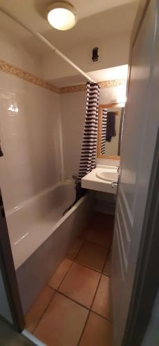 une salle de bain avec une baignoire, un lavabo et un miroir dans l'établissement L'Ourson skis aux pieds, à Valmeinier