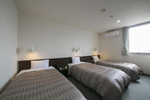 - 3 lits dans une chambre avec fenêtre dans l'établissement Okadaya Bayside - Vacation STAY 00062v, à Toyohashi