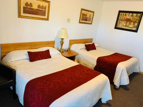 Habitación de hotel con 2 camas con sábanas rojas y blancas en Bo-Mark Motel en North Bay