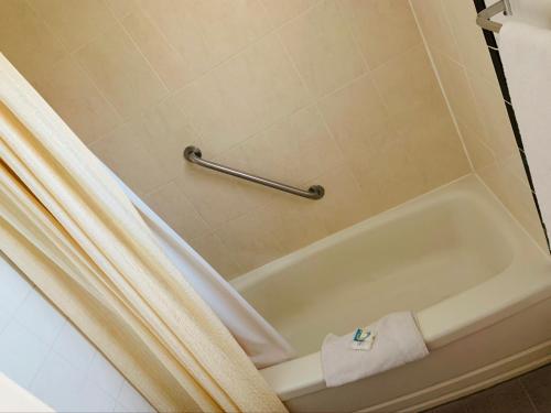 a bathroom with a bath tub with a shower curtain at Bo-Mark Motel in North Bay