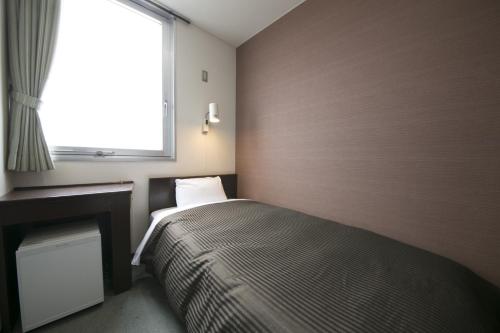ein kleines Schlafzimmer mit einem Bett und einem Fenster in der Unterkunft Okadaya Bayside - Vacation STAY 00055v in Toyohashi