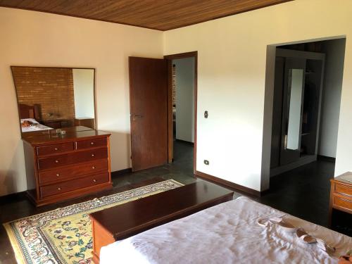 una camera con letto, cassettiera e specchio di Chácara Biritiba Mirim a Biritiba-Mirim