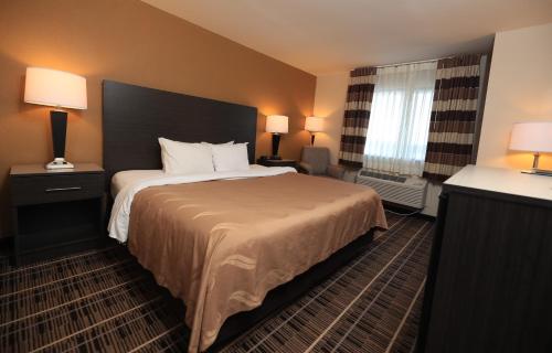 a hotel room with a large bed and a window at Quality Inn DFW Airport North in Irving