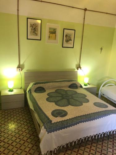 a bedroom with a bed with a flower blanket on it at A casa di nonna Vituccia, nel cuore del Salento! in Neviano