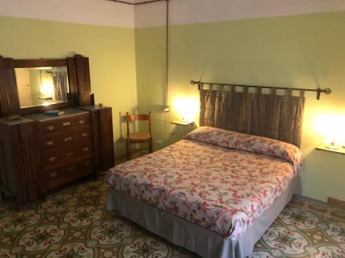 a bedroom with a bed and a dresser and a mirror at A casa di nonna Vituccia, nel cuore del Salento! in Neviano