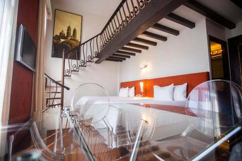 a hotel room with a bed and a staircase at Hotel Herencia By Hosting House in Morelia