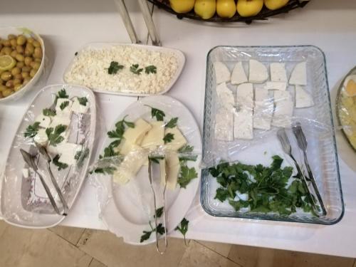 コンヤにあるMEVLANA ŞEMS HOTELのさまざまな種類の食べ物が載ったトレイが置かれたテーブル