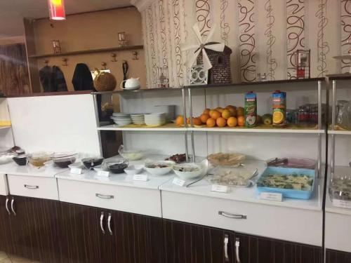 コンヤにあるMEVLANA ŞEMS HOTELの食べ物や果物が詰まった棚のあるキッチン