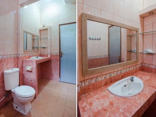 a bathroom with a toilet and a sink and a mirror at Collection O 89999 Hotel Bumi Kedaton Resort in Lampung