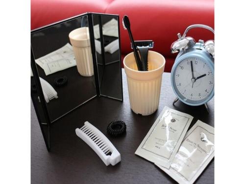 a table with an alarm clock a comb and an alarm clock at OGAL INN - Vacation STAY 01889v in Akaishi
