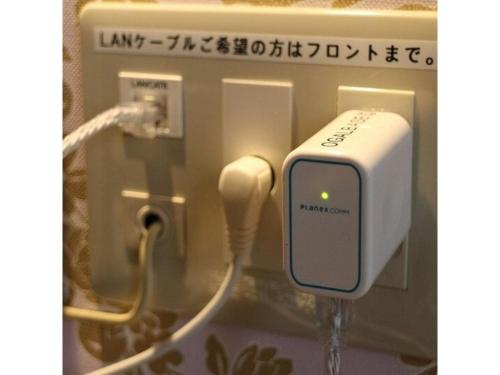 an apple ipod plugged into a socket in a bathroom at OGAL INN - Vacation STAY 01883v in Akaishi