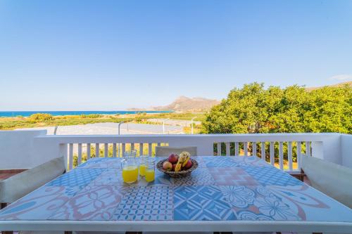 een tafel met een fruitschaal en twee glazen sinaasappelsap bij Villa Smaragdi - Private Sea View Villa in Falasarna