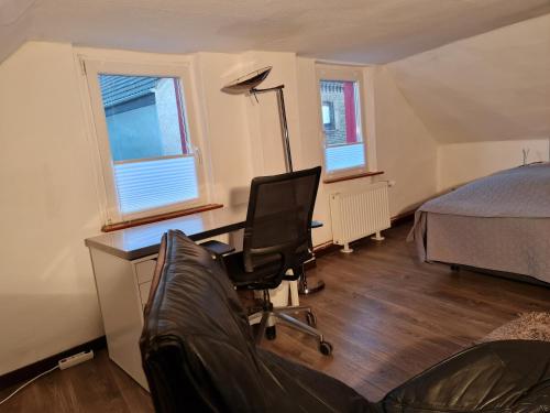 a bedroom with a desk and a bed and a chair at Schönste Lage am Rhein in unmittelbarer Stadtnähe, B & B in Cologne