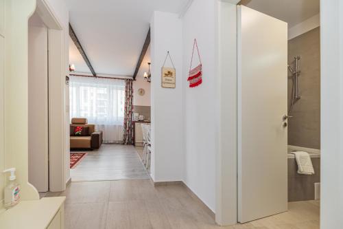 un pasillo con una puerta blanca que conduce a un baño en Dream Apartments Brasov en Brasov