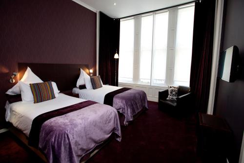 a hotel room with two beds and a window at Carmelite Hotel in Aberdeen