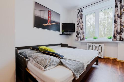 sypialnia z łóżkiem i telewizorem na ścianie w obiekcie deLux1 w Łodzi