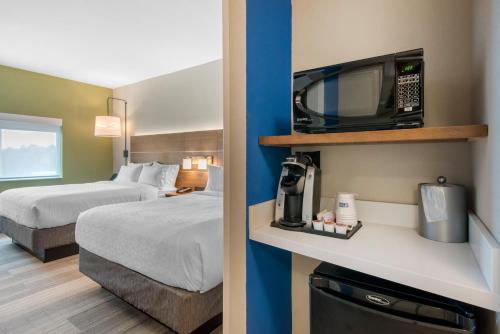 Holiday Inn Express & Suites Alachua - Gainesville Area, an IHG Hotel في ألاتشوا: غرفة في الفندق مع غرفة نوم مع سرير وتلفزيون