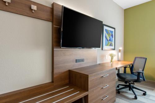 a room with a desk and a flat screen tv at Holiday Inn Express & Suites Alachua - Gainesville Area by IHG in Alachua
