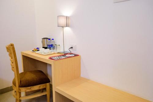 a desk with a chair and a lamp on it at De Lagom Comforts, Anjuna Beach - A boutique hotel in Anjuna