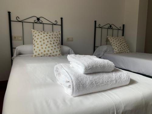2 camas con toallas blancas encima en Oktheway Barro, en Barro