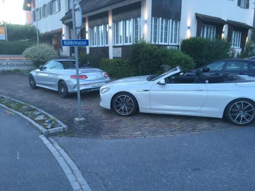 two white cars parked on the side of a street at Hotel Schützenhaus in Uznach