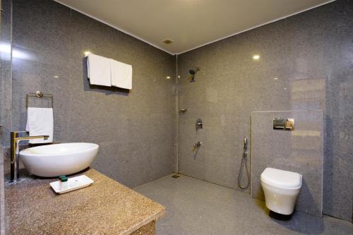 a bathroom with a sink and a shower and a toilet at De Lagom Comforts, Anjuna Beach - A boutique hotel in Anjuna