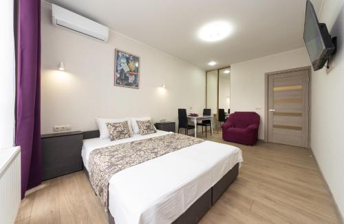 ein Hotelzimmer mit einem Bett und einem Esszimmer in der Unterkunft Апартаменты Central Smart in Kiew