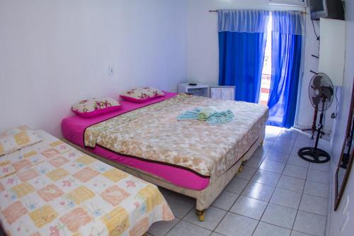 a bedroom with two beds and a window at Hotel Recanto do Mar in Capão da Canoa