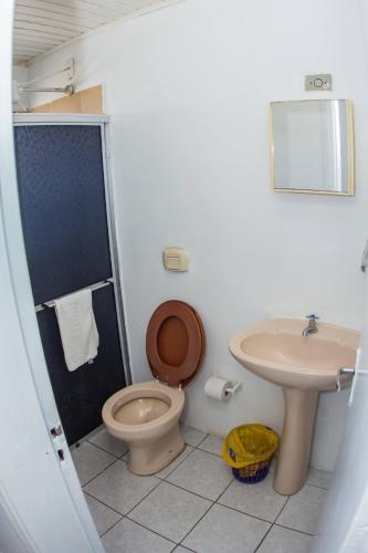 a bathroom with a toilet and a sink at Hotel Recanto do Mar in Capão da Canoa