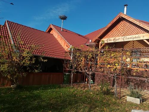 a house with a red roof and some trees at Vár-Liget Vendégház in Kisnána
