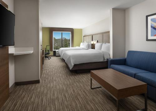 a hotel room with a bed and a couch at Holiday Inn Express Hotel & Suites Olive Branch by IHG in Olive Branch