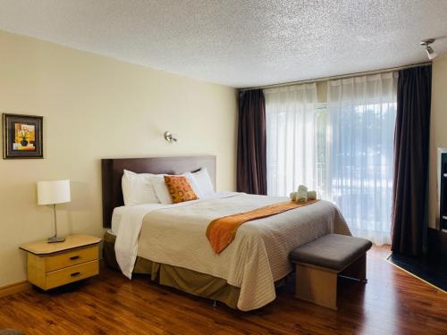 a bedroom with a large bed and a window at Excelsior Hôtel Spa Sainte-Adèle in Sainte-Adèle