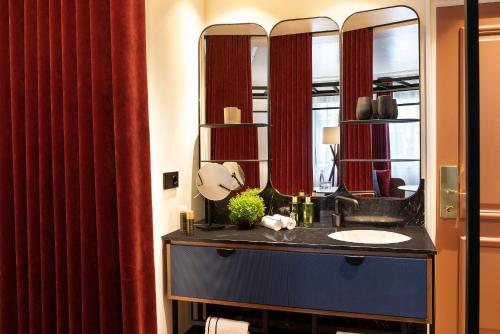 une salle de bain avec un lavabo et un miroir dans l'établissement Villa Marquis Member of Meliá Collection - Champs-Elysées, à Paris