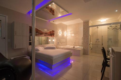 a bedroom with a bed and a shower and a tub at Motel Nix in Santa Maria