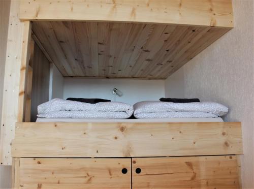 duas camas em cima de uma cómoda de madeira num quarto em Studio tout confort au calme em La Bresse